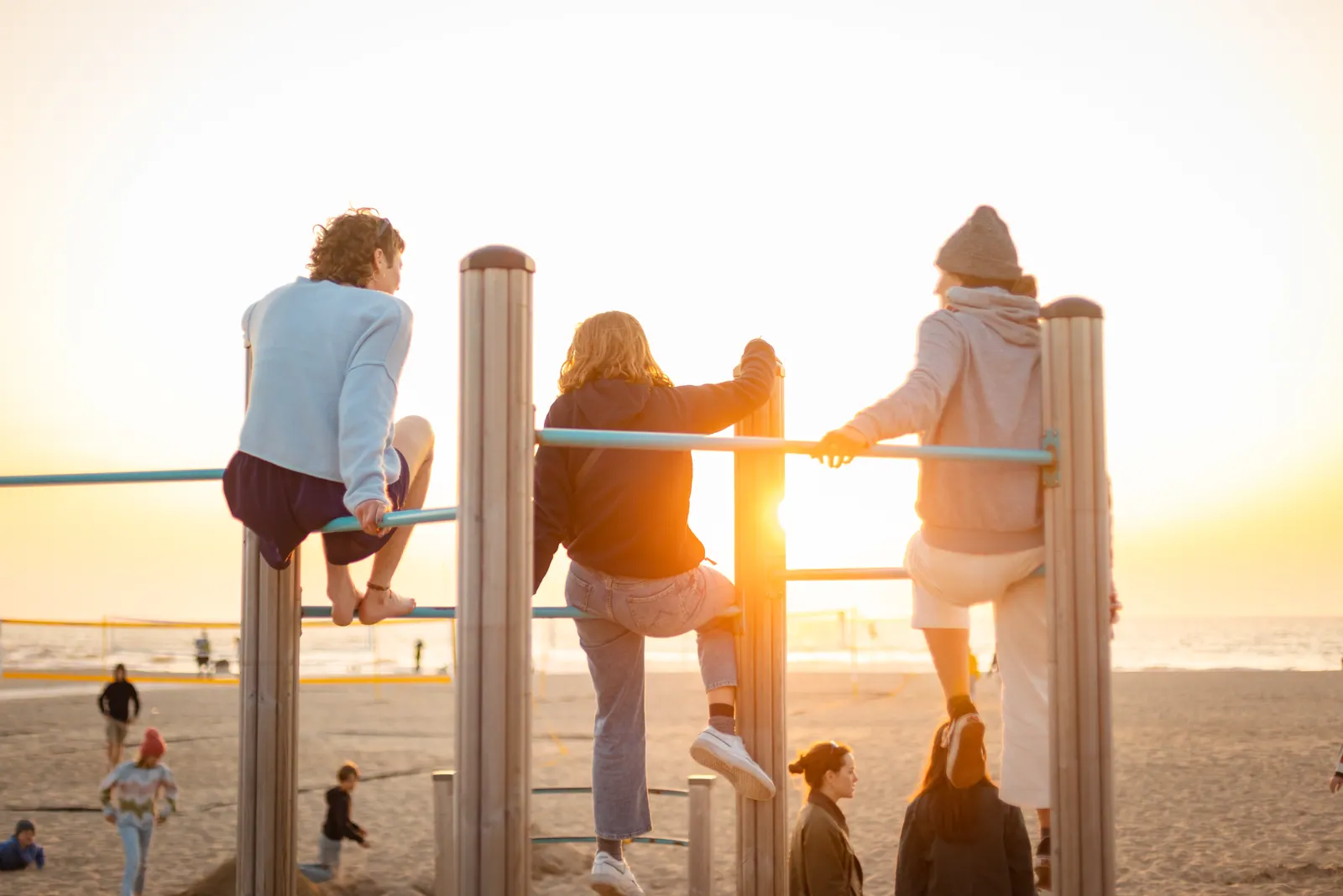Menschen am Steg im Gegenlicht der untergehenden Sonne
